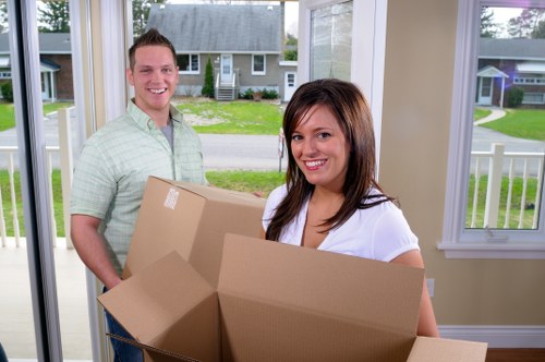 Movers navigating stairs and access challenges in a Harrow property