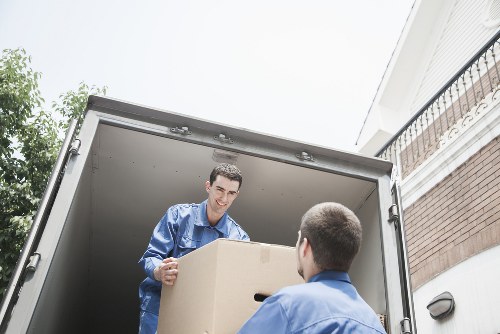 Removal crew loading household items near a Harrow property